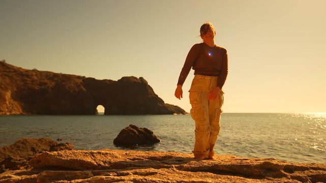 Yoga sunset coastline young woman practicing balance poses on a rocky shore by the ocean during the golden hour