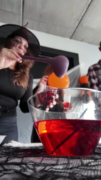 Woman serving red punch at Halloween party