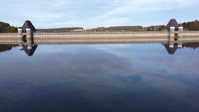 The M&ouml;hne Dam (M&ouml;hnetalsperre) is a masonry dam located in North Rhine-Westphalia, Germany. Aerial view on approach. It is famous for the air raid by the British "Dambusters" during World War II.