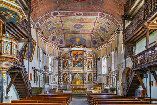 Saint Etienne church interior facing the altar in Espelette, France. Nave view. Golden baroque altarpiece