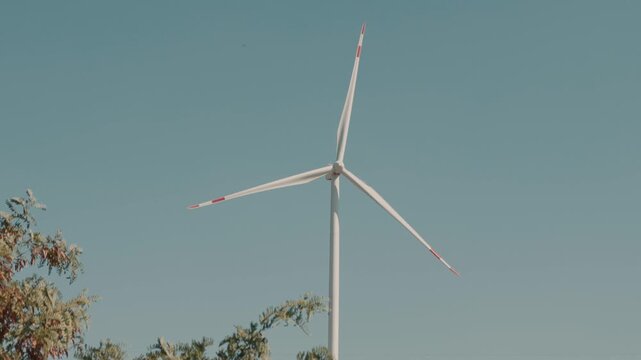 Wind turbine spinning on the wind producing clean green energy. Sustainable alternative power source.