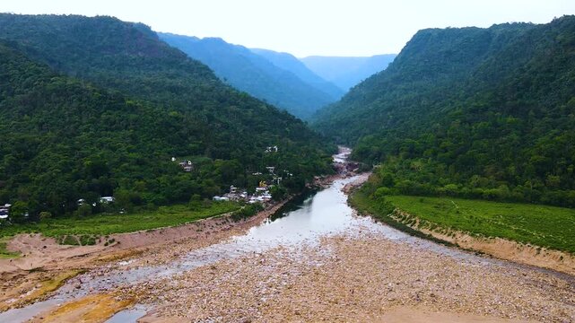 Lush Khasi Hills landscape with exposed riverbed of Piyain River with stone near bangladesh india border area - aerial.