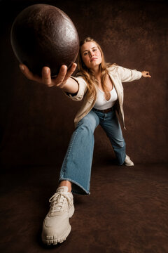 Frau mit Holzkugel in der Hand, dynamische Pose