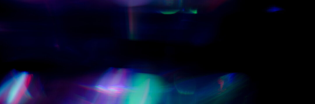 Real holographic crystal lens flare creates soft prismatic light leak clusters along the bottom edge, with a transparent PNG version and a black background preview. Suits holographic background.