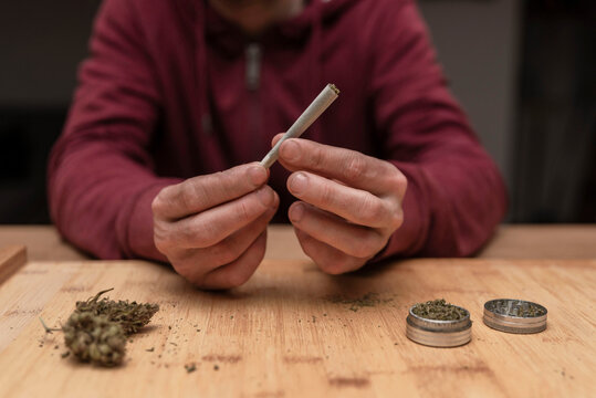 Close up of anonymous man preparing marijuana joint for smoking