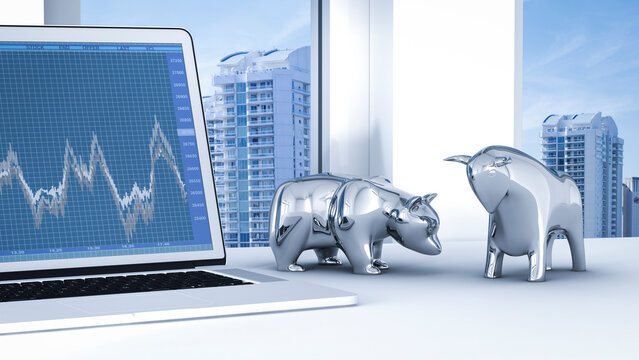 Bull and bear on desk with stock chart on laptop