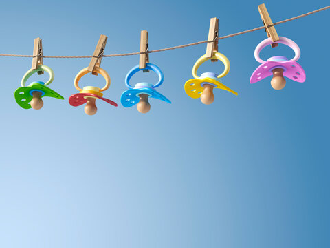 Five pacifiers hanging on a washing line, 3D Rendering