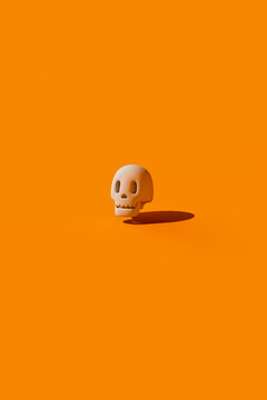 A 3d cartoon skull floats on an orange background