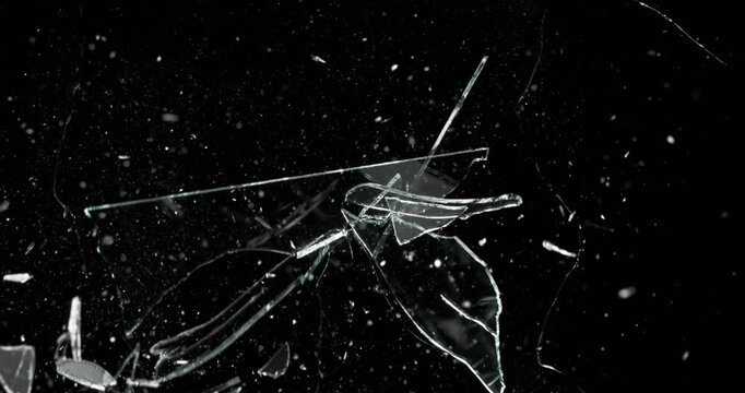 This dynamic footage of glass shattering showcases spontaneous breakage against a stark black background. It is ideal for use in motion graphics and various visual effects applications