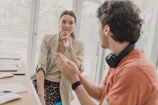 Woman and man discuss business strategy at the office desk