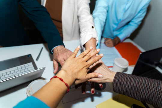 Colleagues stacking hands together for teamwork at the office
