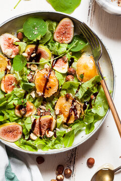 Platter of green salad with figs, Crema di Balsamico, honey hazelnuts and baked goat cheese
