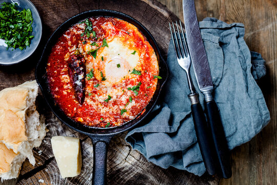 Eggs in Purgatory, eggs, baked in very spicy tomato sauce, sprinkled with parsley and parmegiano