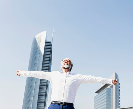 Happy mature businessman cheering in the city