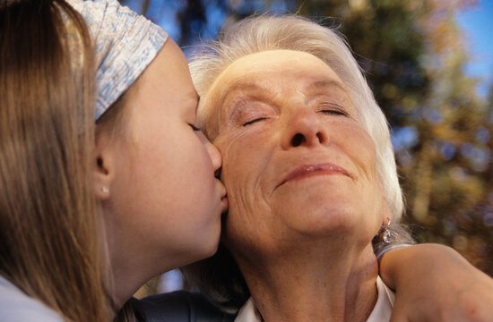 Granddaughter kissing grandmother