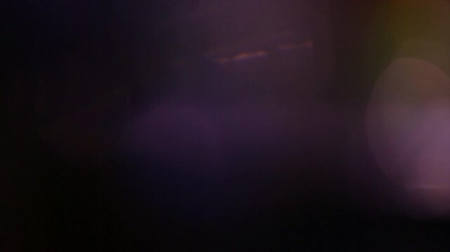 Abstract dark purple and black light leak transition effect.