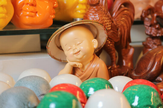 Smiling little monk figurine in conical hat for cute feng shui home decor, tiny buddha statue representing inner peace mindfulness and joy, Vietnam
