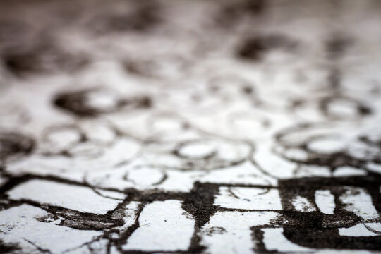 Extreme close up of black acrylic paint texture on paper. Selective focus.