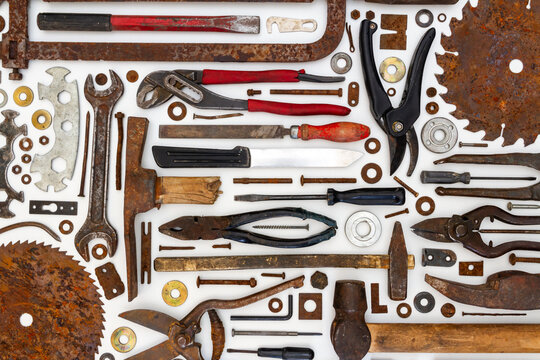 Flat lay of old hand tools on white background. Large collection of various rusty tools and bits arranged on white.