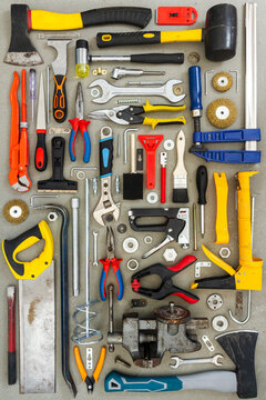 Flat lay of old and new hand tools on concrete background. Large collection of various tools and bits arranged on concrete.
