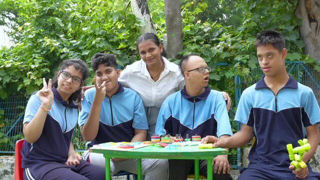 Happy Young students with special needs smiling looking at the camera with female teacher showing a moment of joy and inclusivity during an outdoor educational activity