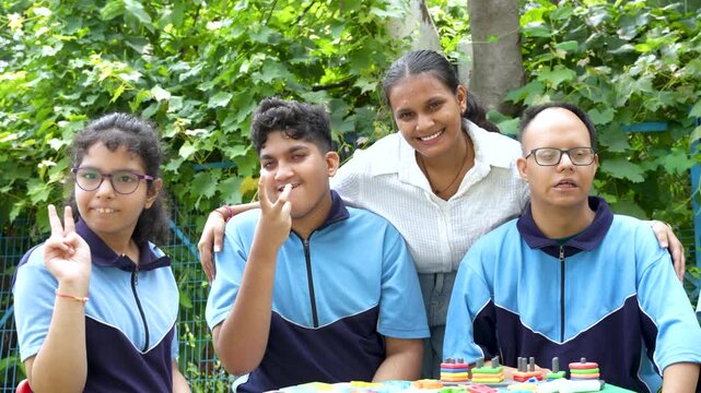 Happy Young students with special needs smiling looking at the camera with female teacher showing a moment of joy and inclusivity during an outdoor educational activity