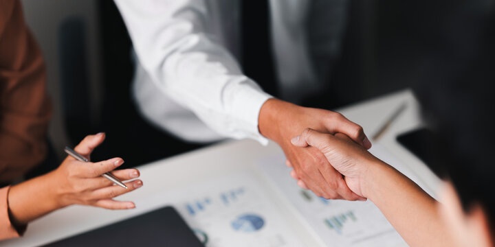 Business colleagues shaking hands during corporate meeting for deal agreement