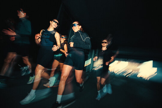 Outdoors at night, running turns group training into an urban club ritual