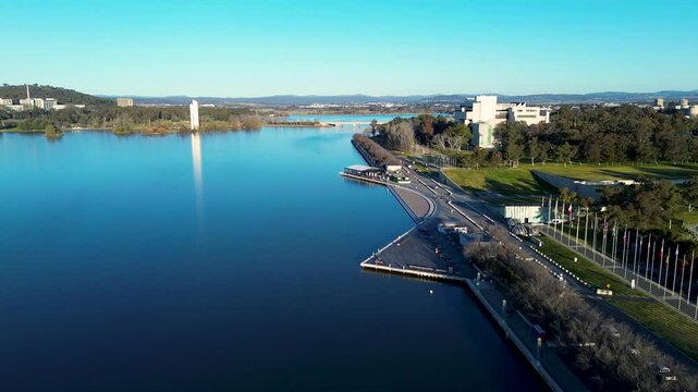 Drone aerial landscape of the waterfront and flag display along the Queen Elizabeth Terrace promenade esplanade at Lake Burley Griffin in Parkes Canberra ACT Australia tourism and infrastructure