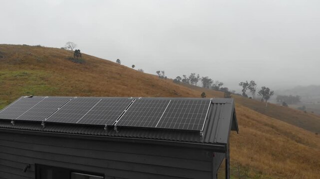 Solar panels installed on an off-grid tiny home in a rural setting. Concept footage representing renewable energy, sustainable living, energy independence and alternative housing.