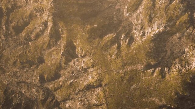 The scene shows rugged mountains and rocky terrain under a clear sky. Shadows from the peaks highlight the textures of the landscape. This view captures the essence of nature in an open area.