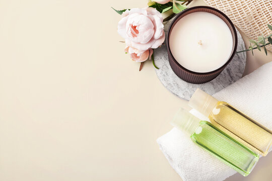 Top view spa background with aroma candle, massage oil bottles and roses with copy space