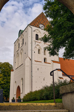 Heliga Kors kyrka in Ronneby historic medieval church architecture and religious heritage in Sweden white stone tower with clock under cloudy sky