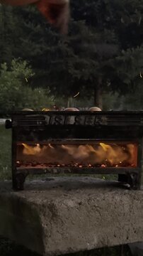 Close Up Fanning the BBQ Fire and Sparks Flying from Glowing Coals in Vertical Format