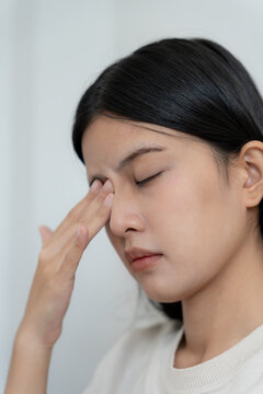 Eye problems, Asian women use hand cover eyes due to eye irritation, eye rubbing, dry, eye pain after read book a long time, migraine, headache, blurred vision, photophobia, small words