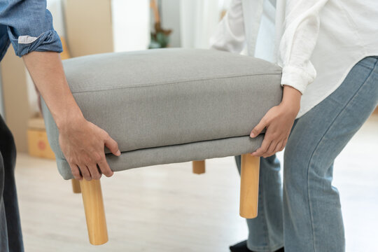 Moving house, relocation. Couple help set sofa and move furniture for new apartment, inside the room was a cardboard box contain personal belongings. move in the new apartment or condominium