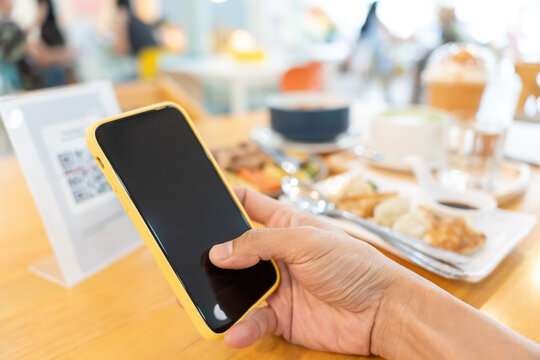 Woman use smartphone to scan QR code to pay in cafe restaurant with a digital payment without cash. Choose menu and order accumulate discount. E wallet, technology, pay online, credit card, bank app.