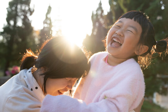 Happy Mom smile for daughter and playing together outdoors Family Childhood development and growth with love for her Mom's concern Happy baby dream Support