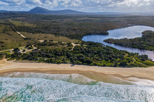 Aerial view of Lake Arragan Beach and campground on the NSW North Coast, featuring the sandy shoreline, coastal camping area, native bushland and Pacific Ocean within Yuraygir National Park