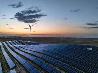 Wind turbines and solar panels at sunset © zhu difeng