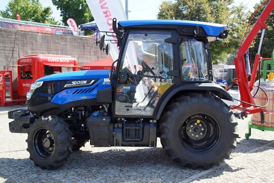 Solis blue agricultural tractor parked at outdoor exhibition