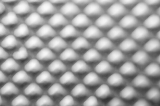Textured surface of a gray plastic material with raised diamond patterns, providing a modern and industrial aesthetic suitable for various design applications