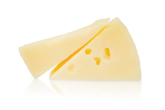 Yellow cheese wedge with holes and a diagonal cut, placed on a reflective white surface, showcasing its texture and color against a clean background