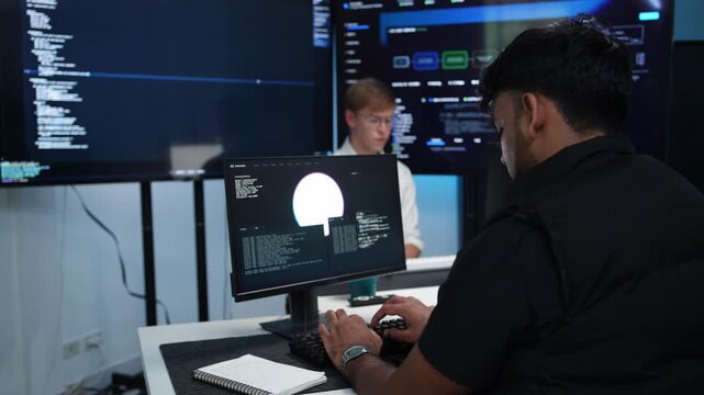 Dedicated software developers working together in a contemporary workspace utilizing cutting edge technology and coding on their displays