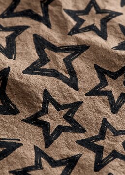 Close-up of a fabric with a repeating pattern of black stars on a beige background. the stars are all the same size and shape, and they are arranged in a random, overlapping manner.