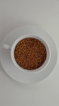 Rotating Cup of Instant Coffee Granules Seamless Loop.
Top view of a white cup filled with dry coffee granules rotating on a matching saucer.