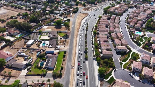 Aerial View shows a 2 mile Line of Cars attempting to merge onto the Interstate 15 Southbound on a Friday afternoon in Corona California. A daily occurrence in this heavily congested area.