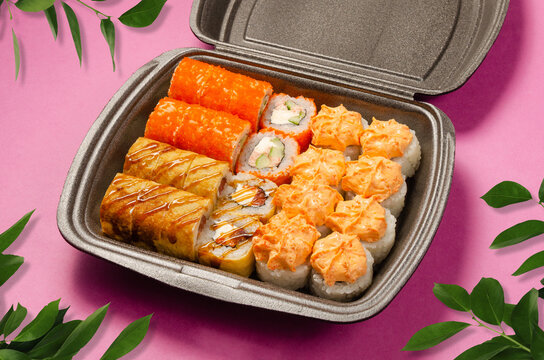 Assorted Sushi Set with Rolls in Takeaway Box on Pink Background