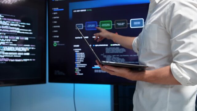 Business professional presenting data insights on digital screen with laptop in modern conference room