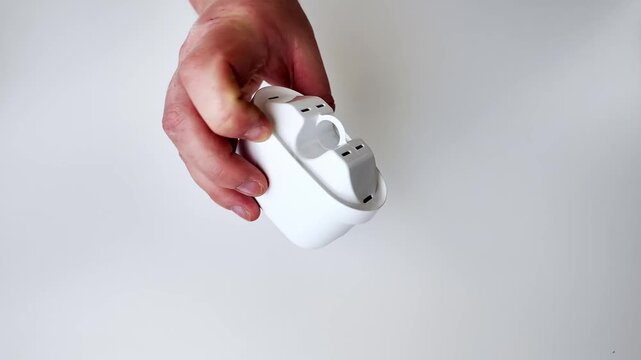 A close up view of a modern white electronic device resting on a clean white surface, conveying simplicity and technology, perfect for tech product showcases or minimalist design themes